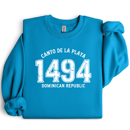 Gildan sweatshirt with “Canto De La Playa 1494 Dominican Republic” printed in distressed navy text. Vintage beach-inspired crewneck symbolizing Caribbean heritage and coastal charm. Made from soft cotton-poly blend fabric for comfort and style, ideal for beach lovers and travelers who adore Dominican culture. Cozy, sustainable, and perfect for casual wear or tropical getaways.