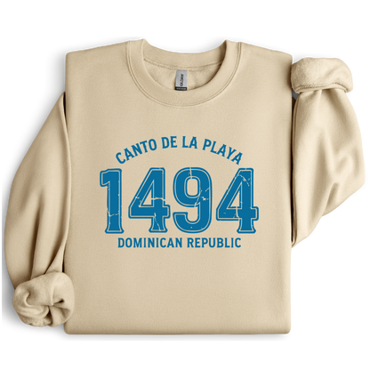 Gildan sweatshirt with “Canto De La Playa 1494 Dominican Republic” printed in distressed navy text. Vintage beach-inspired crewneck symbolizing Caribbean heritage and coastal charm. Made from soft cotton-poly blend fabric for comfort and style, ideal for beach lovers and travelers who adore Dominican culture. Cozy, sustainable, and perfect for casual wear or tropical getaways.