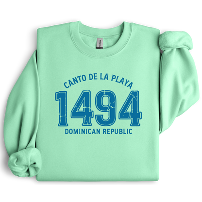 Gildan sweatshirt with “Canto De La Playa 1494 Dominican Republic” printed in distressed navy text. Vintage beach-inspired crewneck symbolizing Caribbean heritage and coastal charm. Made from soft cotton-poly blend fabric for comfort and style, ideal for beach lovers and travelers who adore Dominican culture. Cozy, sustainable, and perfect for casual wear or tropical getaways.