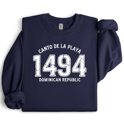 Gildan sweatshirt with “Canto De La Playa 1494 Dominican Republic” printed in distressed navy text. Vintage beach-inspired crewneck symbolizing Caribbean heritage and coastal charm. Made from soft cotton-poly blend fabric for comfort and style, ideal for beach lovers and travelers who adore Dominican culture. Cozy, sustainable, and perfect for casual wear or tropical getaways.