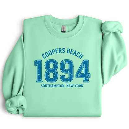 Mint green sweatshirt with blue text 'Coopers Beach 1894 Southampton, New York' on a white background