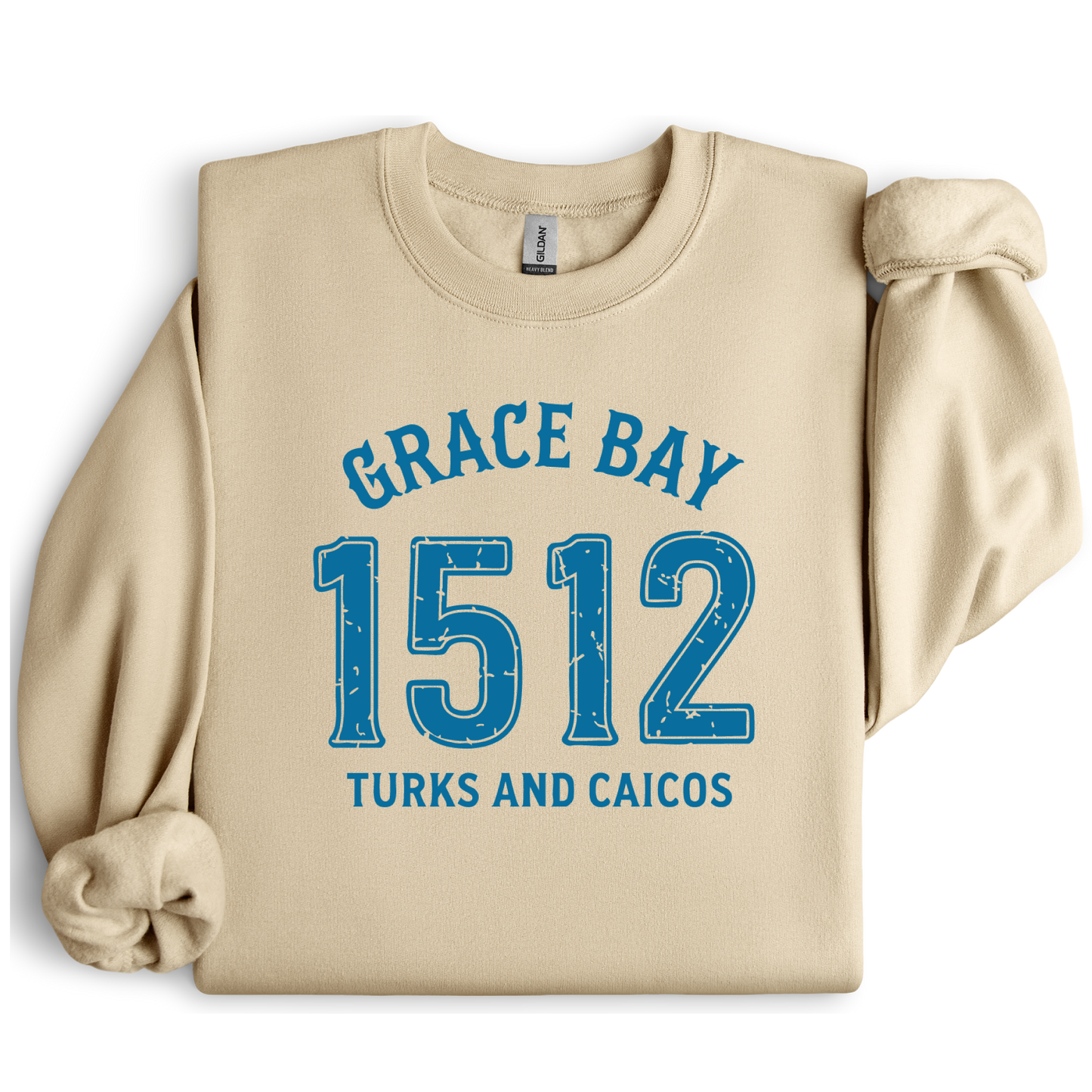 Gildan sweatshirt featuring blue text that reads “Grace Bay 1512 Turks and Caicos” in a vintage collegiate style. Cozy cotton-poly blend pullover with ribbed cuffs and waistband for a relaxed, durable fit. Ideal for beach lovers, island travelers, and fans of coastal fashion. Perfect for staying cozy while showcasing love for one of the Caribbean’s most beautiful beaches — Grace Bay.