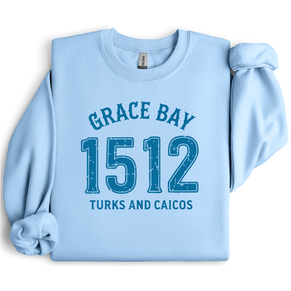 Gildan sweatshirt featuring blue text that reads “Grace Bay 1512 Turks and Caicos” in a vintage collegiate style. Cozy cotton-poly blend pullover with ribbed cuffs and waistband for a relaxed, durable fit. Ideal for beach lovers, island travelers, and fans of coastal fashion. Perfect for staying cozy while showcasing love for one of the Caribbean’s most beautiful beaches — Grace Bay.