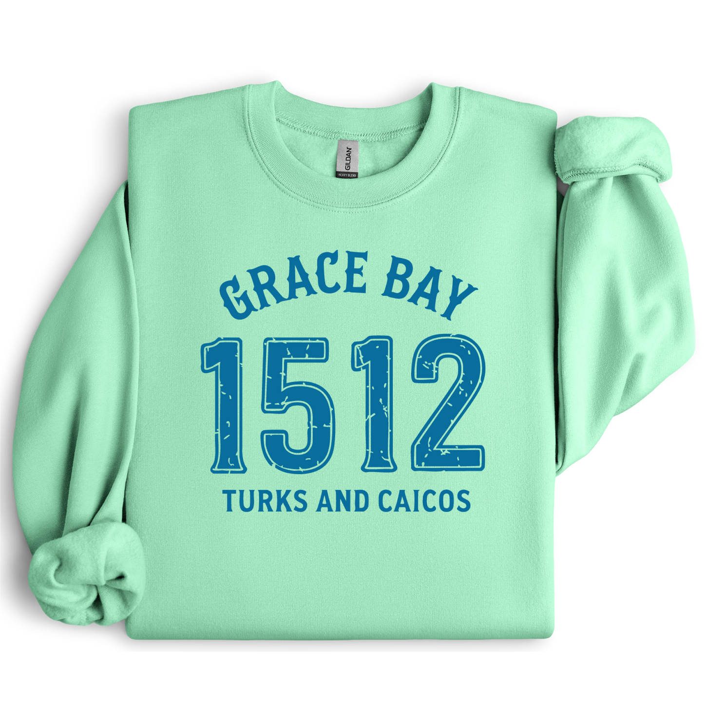 Gildan sweatshirt featuring blue text that reads “Grace Bay 1512 Turks and Caicos” in a vintage collegiate style. Cozy cotton-poly blend pullover with ribbed cuffs and waistband for a relaxed, durable fit. Ideal for beach lovers, island travelers, and fans of coastal fashion. Perfect for staying cozy while showcasing love for one of the Caribbean’s most beautiful beaches — Grace Bay.
