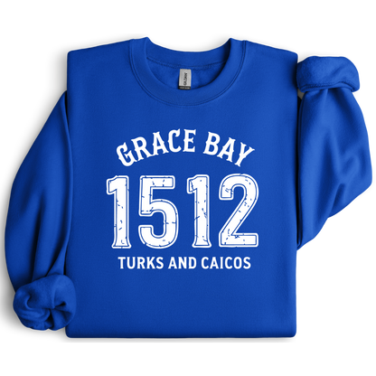 Gildan sweatshirt featuring blue text that reads “Grace Bay 1512 Turks and Caicos” in a vintage collegiate style. Cozy cotton-poly blend pullover with ribbed cuffs and waistband for a relaxed, durable fit. Ideal for beach lovers, island travelers, and fans of coastal fashion. Perfect for staying cozy while showcasing love for one of the Caribbean’s most beautiful beaches — Grace Bay.