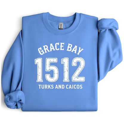 Gildan sweatshirt featuring blue text that reads “Grace Bay 1512 Turks and Caicos” in a vintage collegiate style. Cozy cotton-poly blend pullover with ribbed cuffs and waistband for a relaxed, durable fit. Ideal for beach lovers, island travelers, and fans of coastal fashion. Perfect for staying cozy while showcasing love for one of the Caribbean’s most beautiful beaches — Grace Bay.