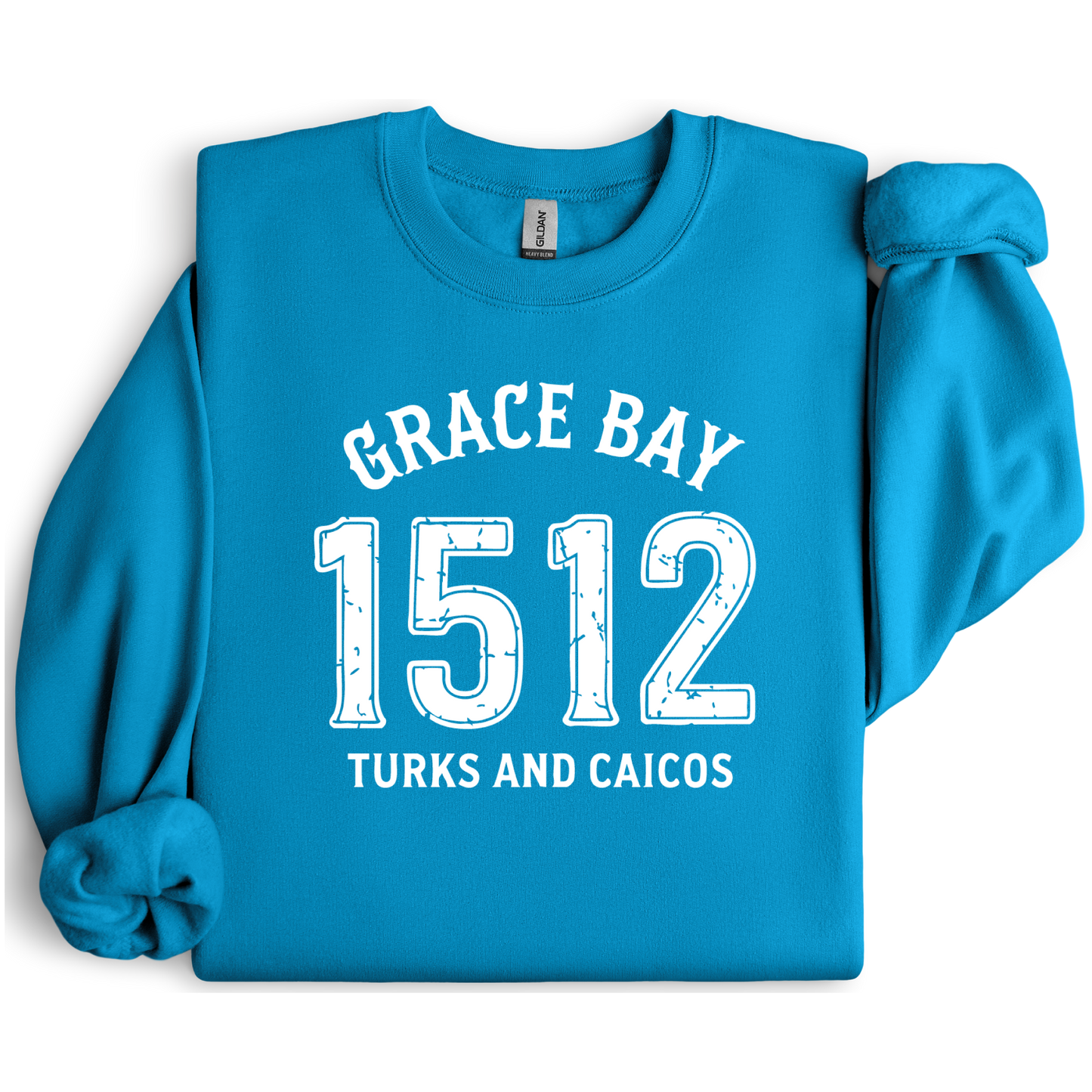 Gildan sweatshirt featuring blue text that reads “Grace Bay 1512 Turks and Caicos” in a vintage collegiate style. Cozy cotton-poly blend pullover with ribbed cuffs and waistband for a relaxed, durable fit. Ideal for beach lovers, island travelers, and fans of coastal fashion. Perfect for staying cozy while showcasing love for one of the Caribbean’s most beautiful beaches — Grace Bay.