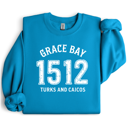 Gildan sweatshirt featuring blue text that reads “Grace Bay 1512 Turks and Caicos” in a vintage collegiate style. Cozy cotton-poly blend pullover with ribbed cuffs and waistband for a relaxed, durable fit. Ideal for beach lovers, island travelers, and fans of coastal fashion. Perfect for staying cozy while showcasing love for one of the Caribbean’s most beautiful beaches — Grace Bay.