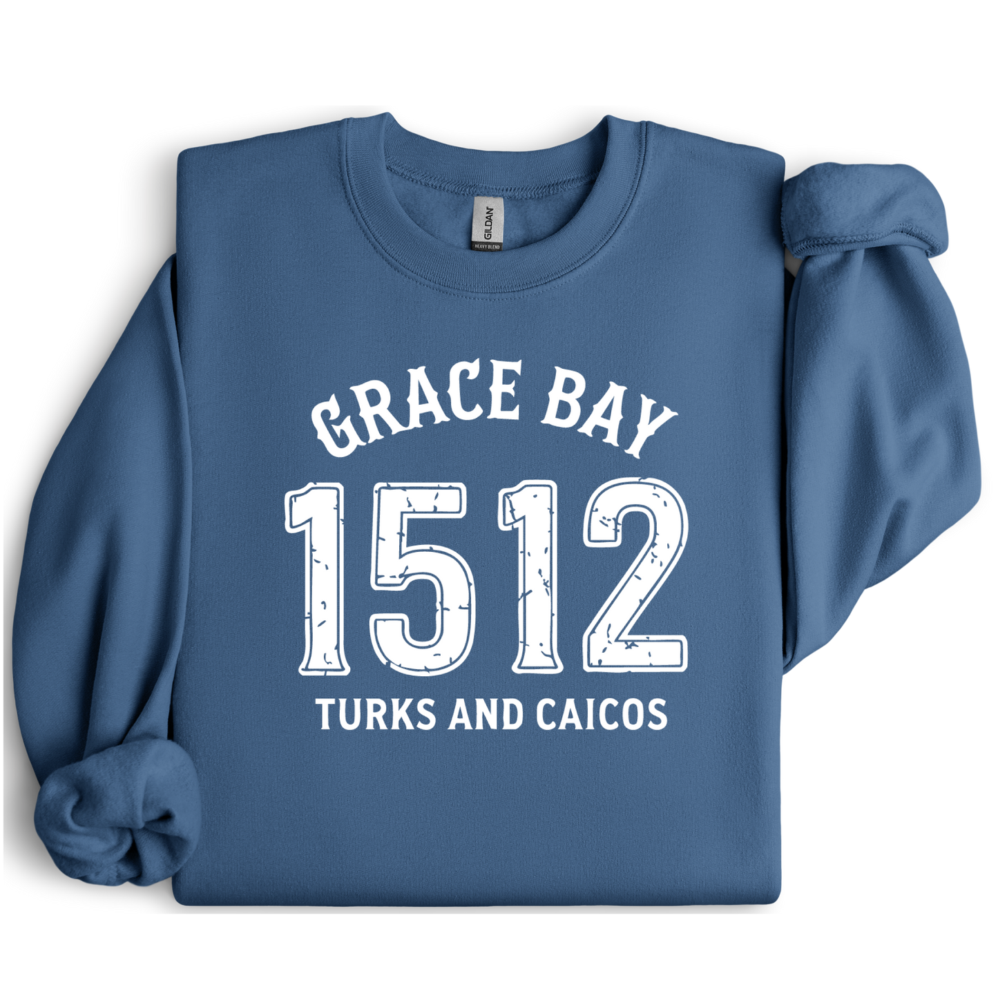 Gildan sweatshirt featuring blue text that reads “Grace Bay 1512 Turks and Caicos” in a vintage collegiate style. Cozy cotton-poly blend pullover with ribbed cuffs and waistband for a relaxed, durable fit. Ideal for beach lovers, island travelers, and fans of coastal fashion. Perfect for staying cozy while showcasing love for one of the Caribbean’s most beautiful beaches — Grace Bay.