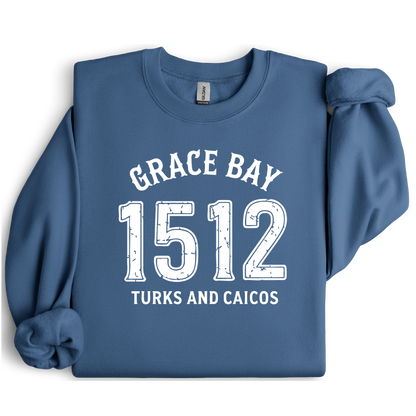 Gildan sweatshirt featuring blue text that reads “Grace Bay 1512 Turks and Caicos” in a vintage collegiate style. Cozy cotton-poly blend pullover with ribbed cuffs and waistband for a relaxed, durable fit. Ideal for beach lovers, island travelers, and fans of coastal fashion. Perfect for staying cozy while showcasing love for one of the Caribbean’s most beautiful beaches — Grace Bay.