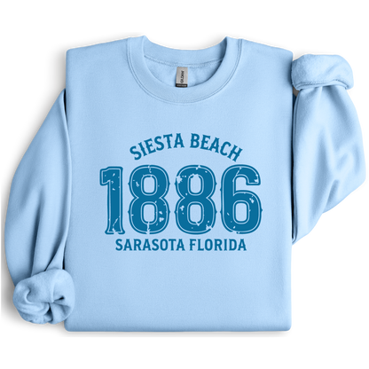 Light blue sweatshirt with 'Siesta Beach 1886 Sarasota Florida' text on a white background