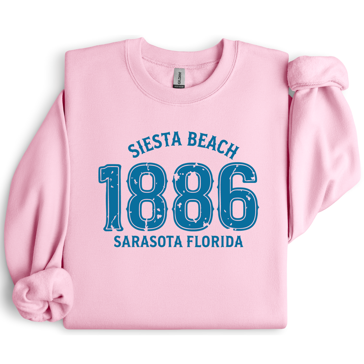 Pink sweatshirt with blue text 'Siesta Beach 1886 Sarasota Florida' on a white background