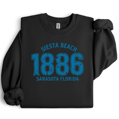 Black sweatshirt with blue text 'Siesta Beach 1886 Sarasota Florida' on a white background