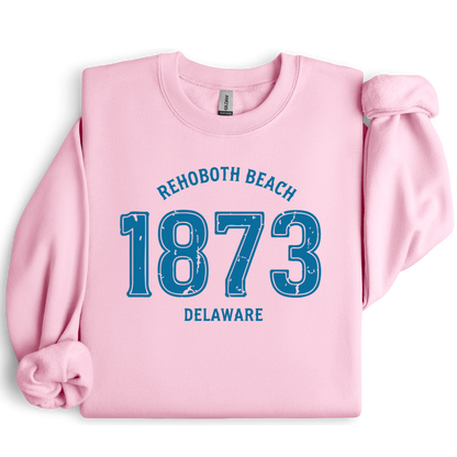 Pink sweatshirt with blue text 'Rehoboth Beach 1873 Delaware' on a white background