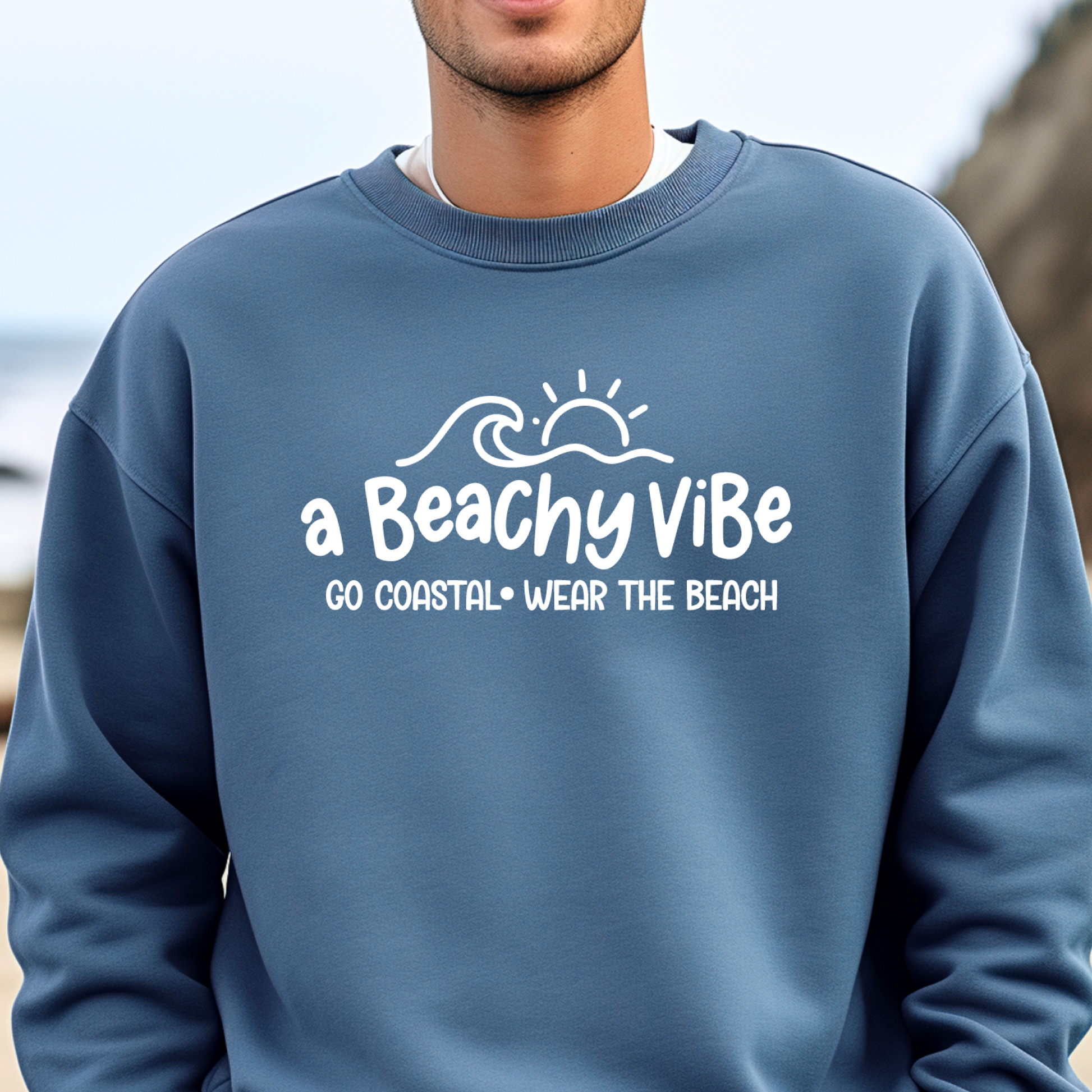 Person wearing a indigo blue sweatshirt with 'a Beachy Vibe' text and design.