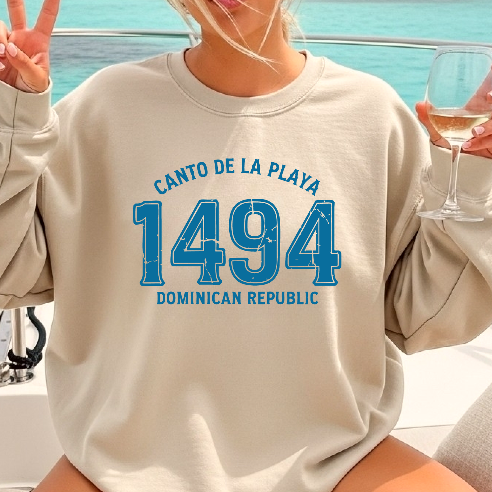 Gildan sweatshirt with “Canto De La Playa 1494 Dominican Republic” printed in distressed navy text. Vintage beach-inspired crewneck symbolizing Caribbean heritage and coastal charm. Made from soft cotton-poly blend fabric for comfort and style, ideal for beach lovers and travelers who adore Dominican culture. Cozy, sustainable, and perfect for casual wear or tropical getaways.