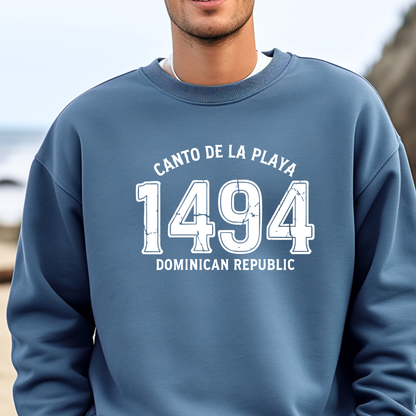 Gildan sweatshirt with “Canto De La Playa 1494 Dominican Republic” printed in distressed navy text. Vintage beach-inspired crewneck symbolizing Caribbean heritage and coastal charm. Made from soft cotton-poly blend fabric for comfort and style, ideal for beach lovers and travelers who adore Dominican culture. Cozy, sustainable, and perfect for casual wear or tropical getaways.