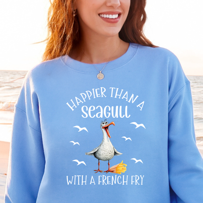 Person wearing a Carolina blue sweatshirt with a seagull graphic and text at a beach.