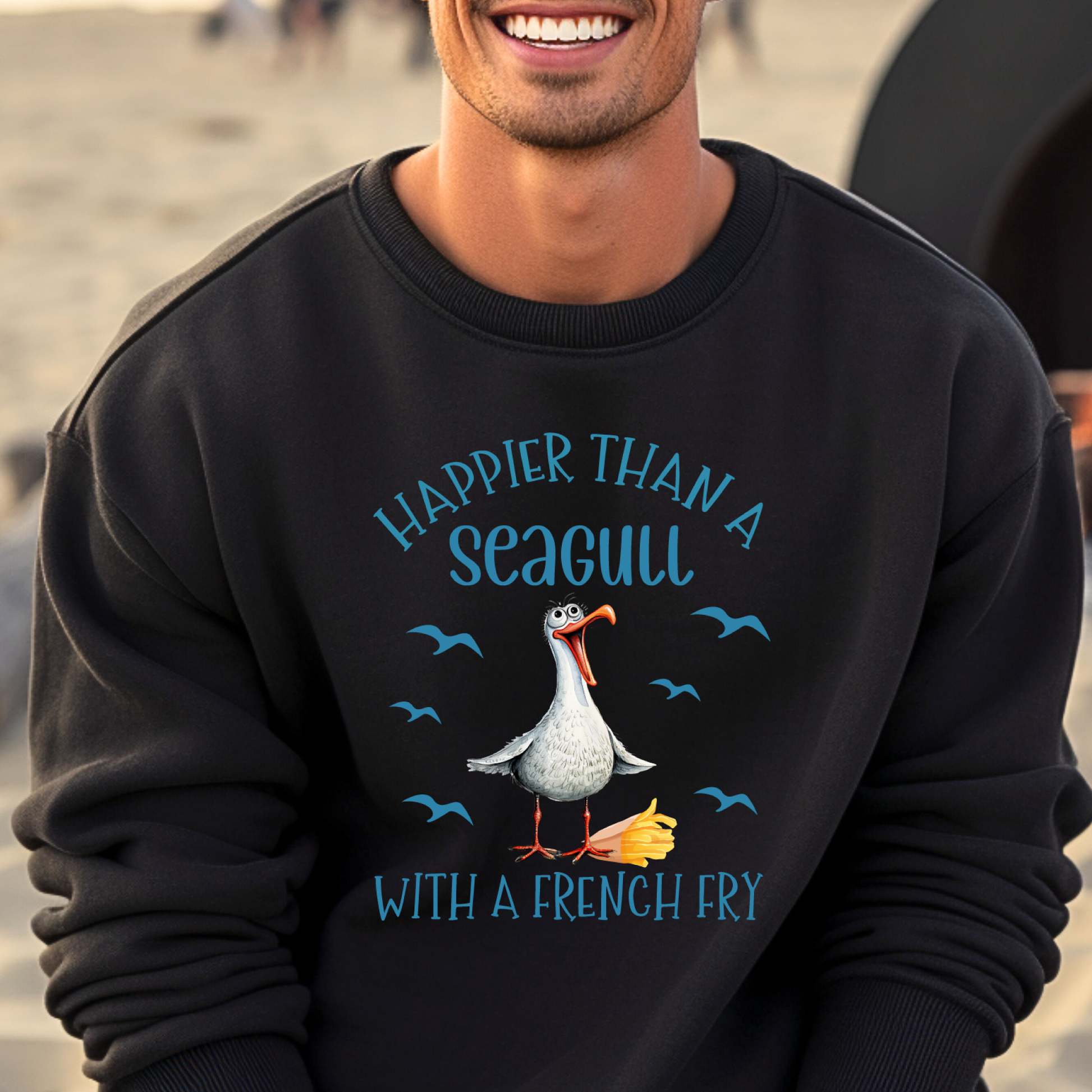 Person wearing a black sweatshirt with a seagull graphic and text on a beach.