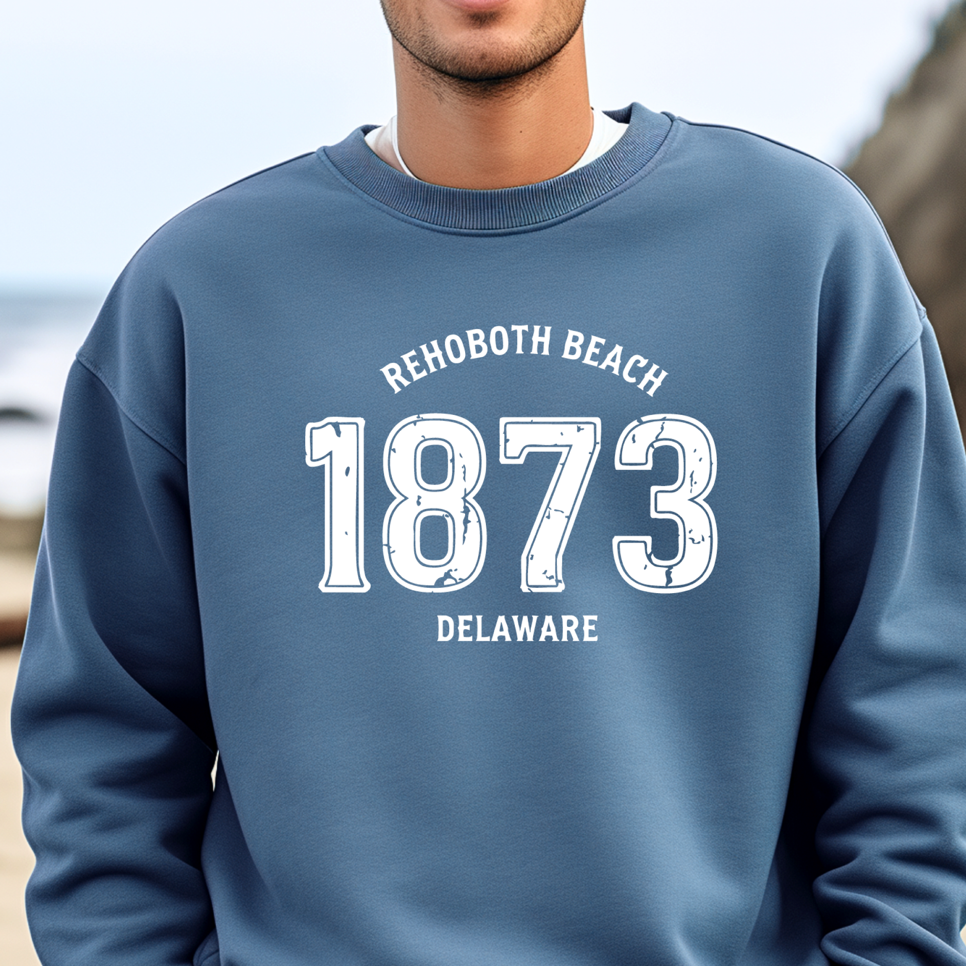 Person wearing a indigo blue sweatshirt with 'Rehoboth Beach 1873 Delaware' text.