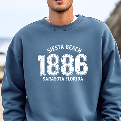 Person wearing a indigo blue sweatshirt with 'Siesta Beach 1886 Sarasota Florida' text.